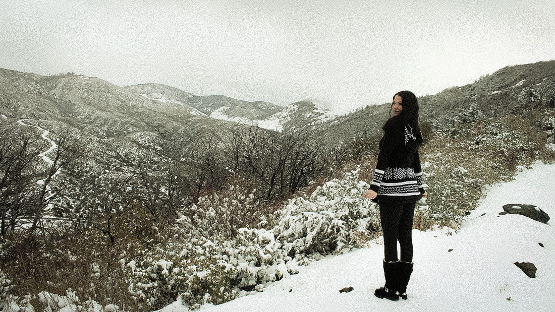 Woman looks out over a snowy mountain view